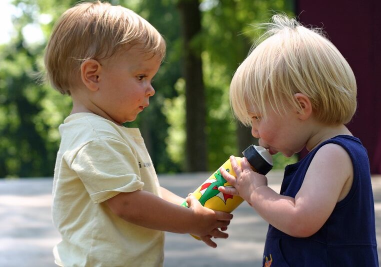 Babies Sharing Bottle